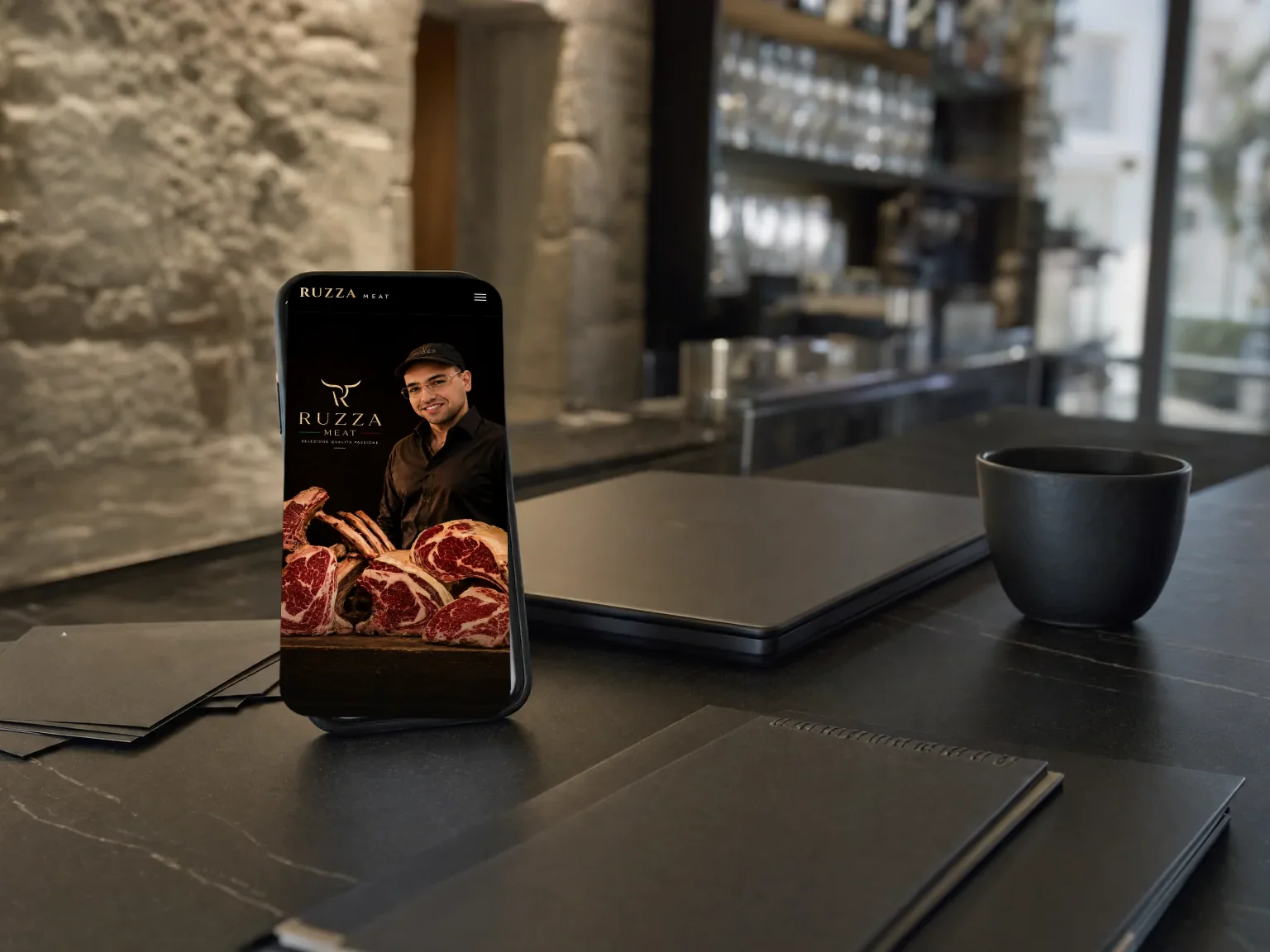 Telefono sul bancone di un locale, con il sito Ruzza Meat aperto.